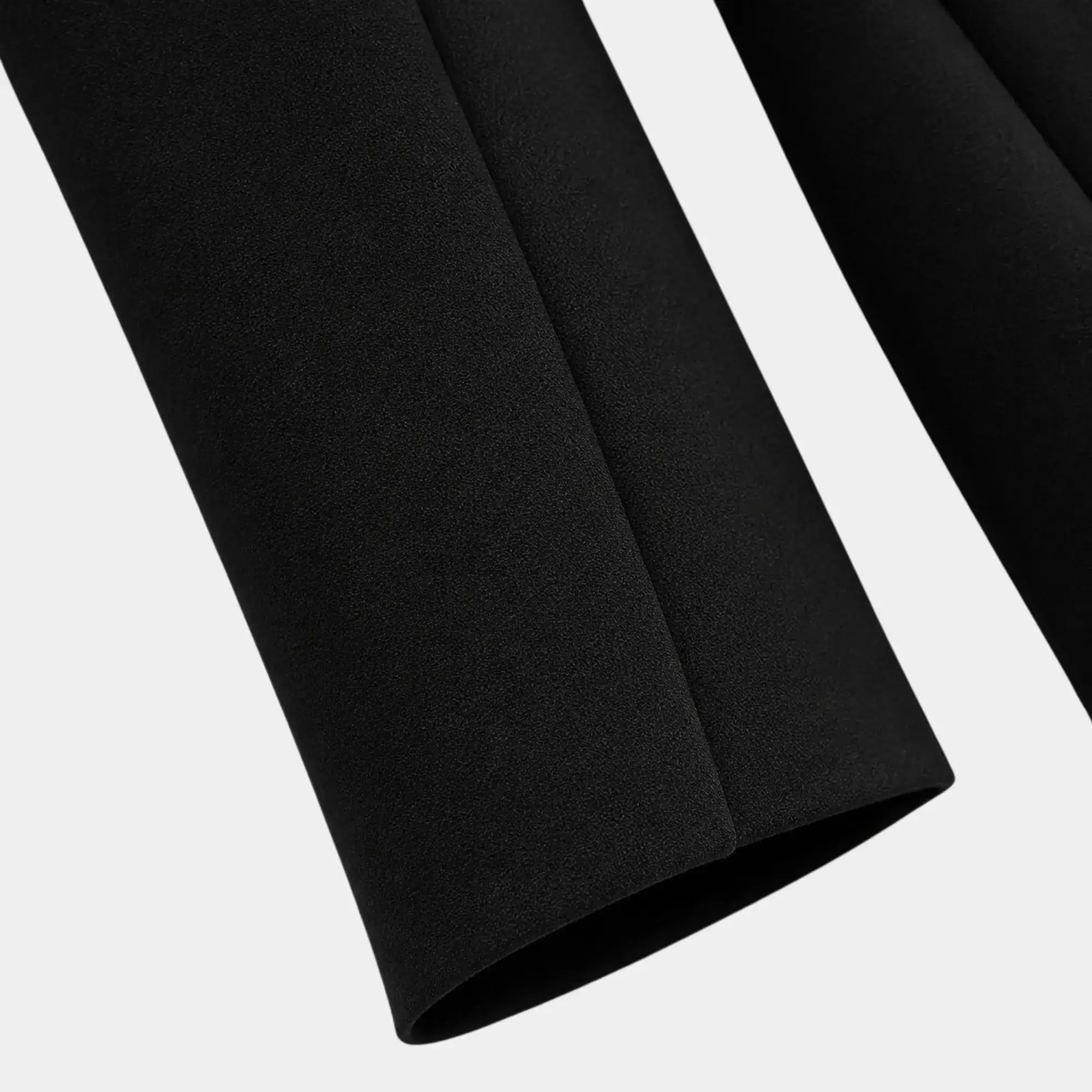 Detalhe da barra da manga do blazer feminino preto de alfaiataria com acabamento refinado.