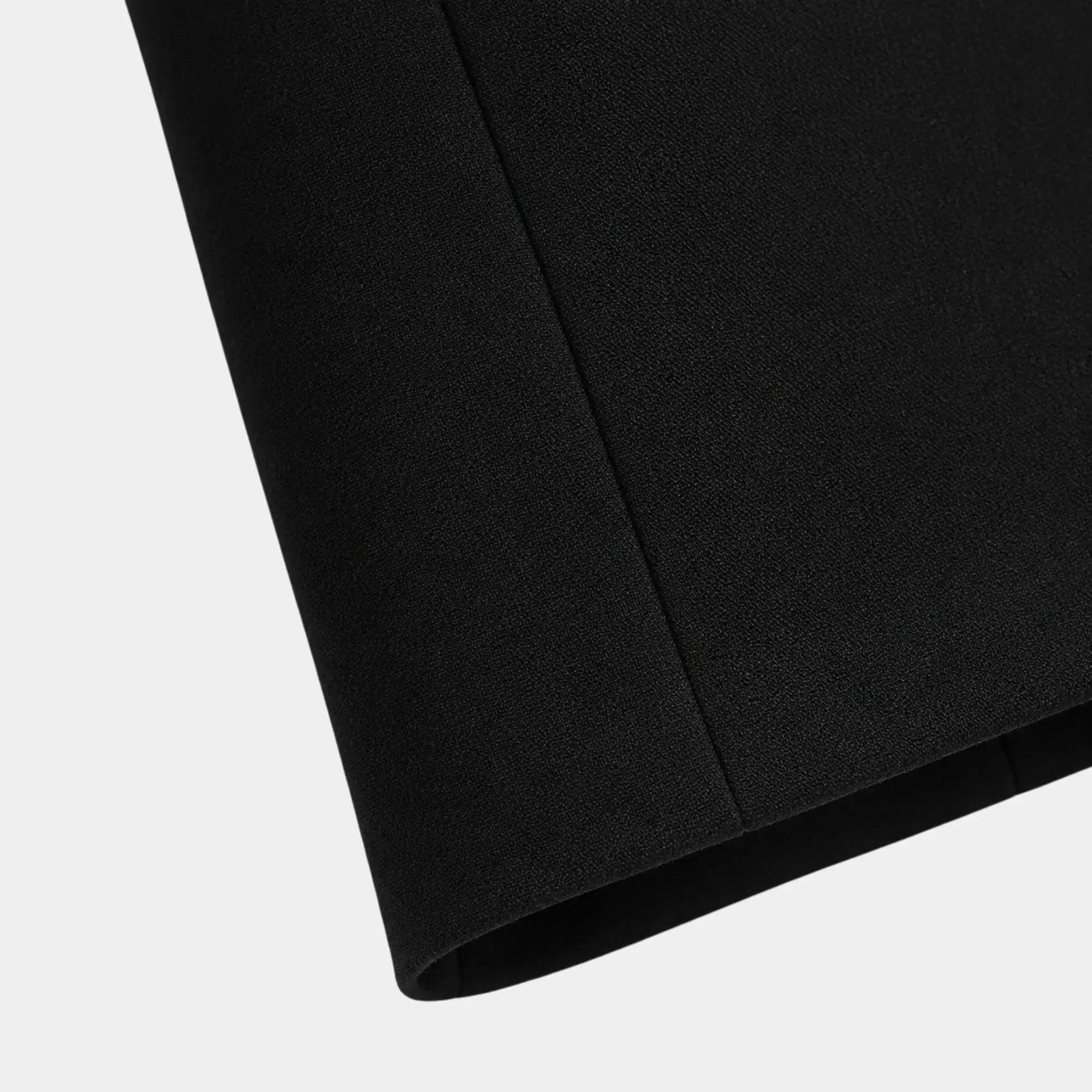 Detalhe da barra do blazer feminino preto de alfaiataria com acabamento refinado e costura precisa.