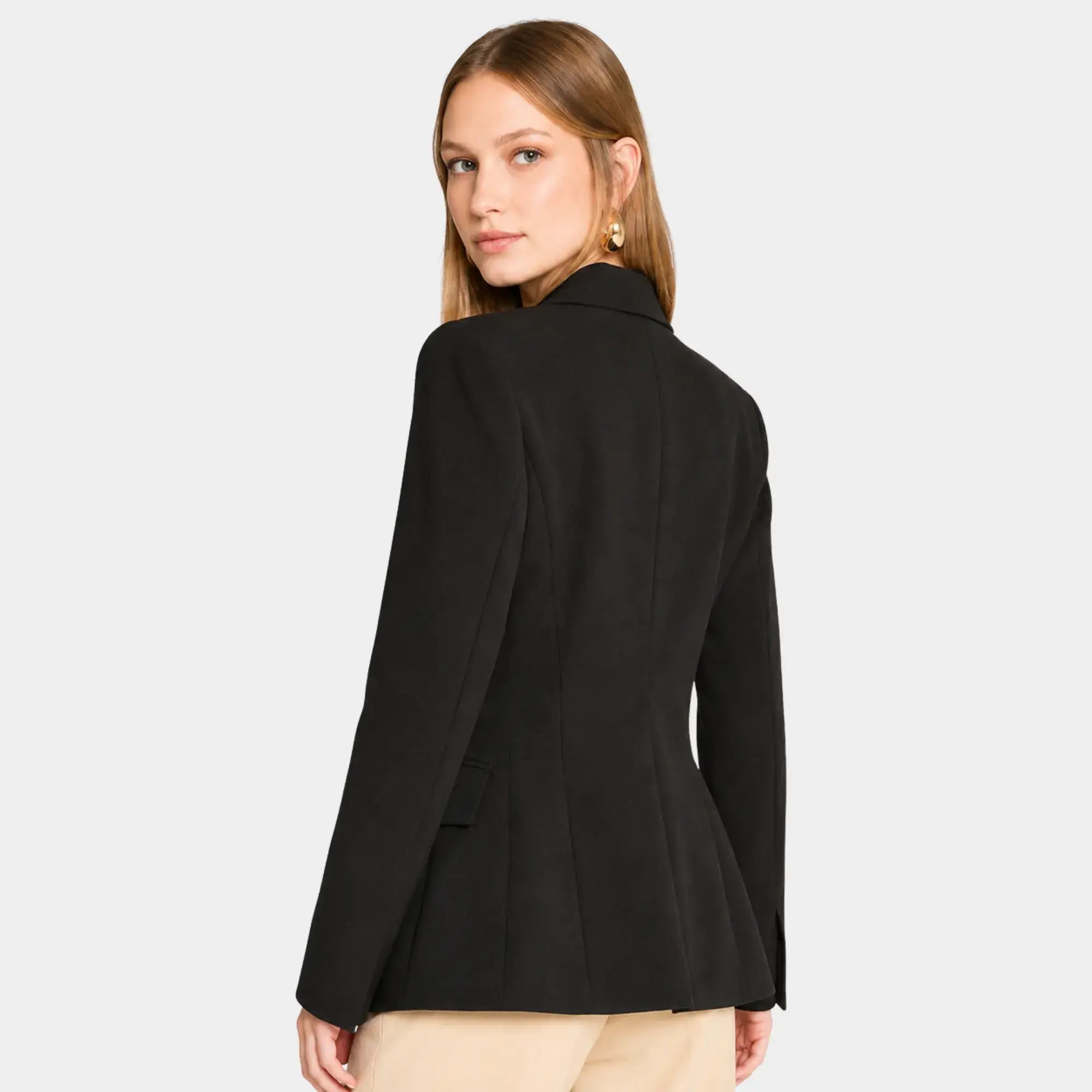 Mulher usando blazer feminino de alfaiataria preto acinturado visto de costas com caimento elegante e estruturado.