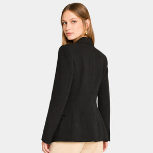 Mulher usando blazer feminino de alfaiataria preto acinturado visto de costas com caimento elegante e estruturado.