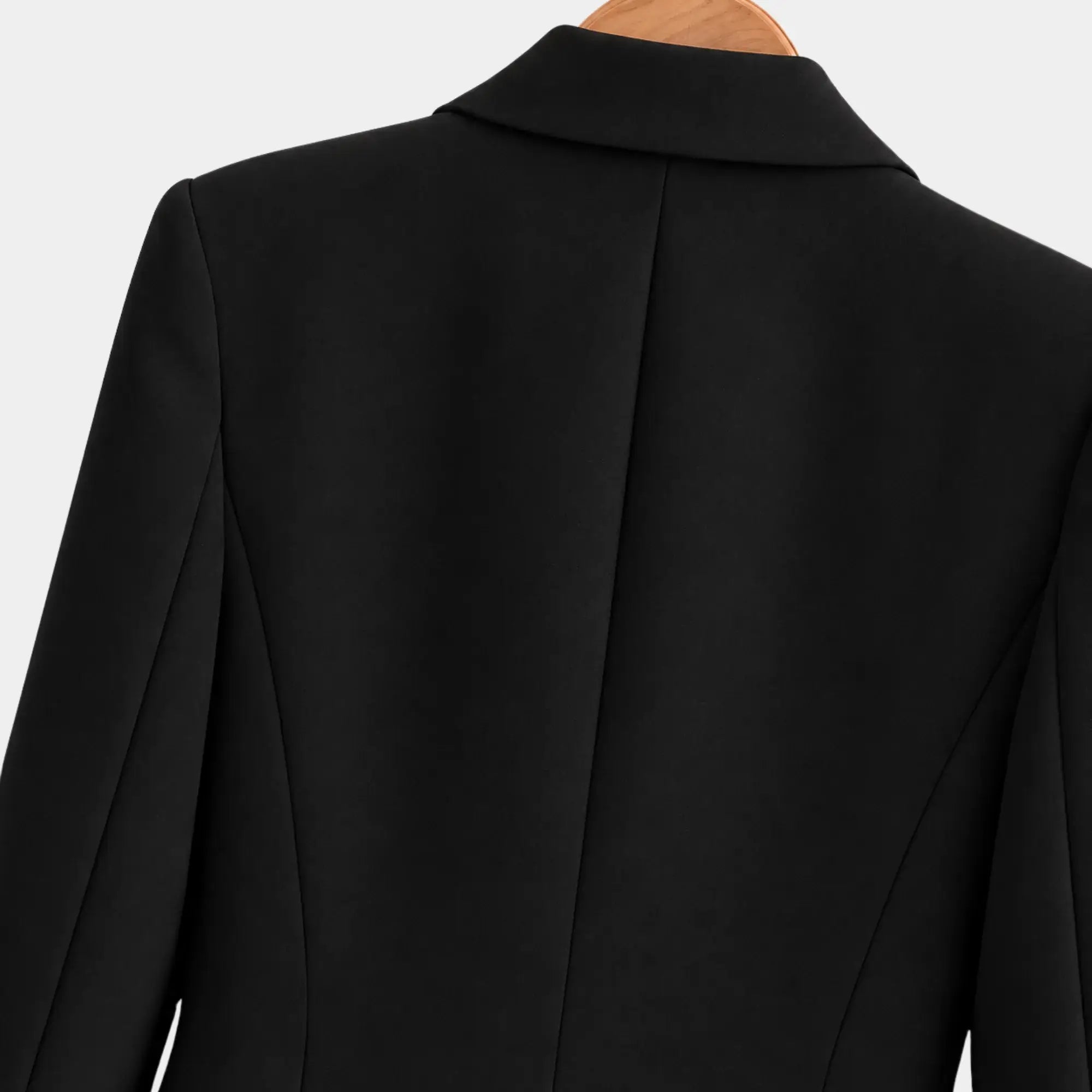 Detalhe das costas do blazer feminino preto de alfaiataria com recortes estruturados e acabamento refinado.