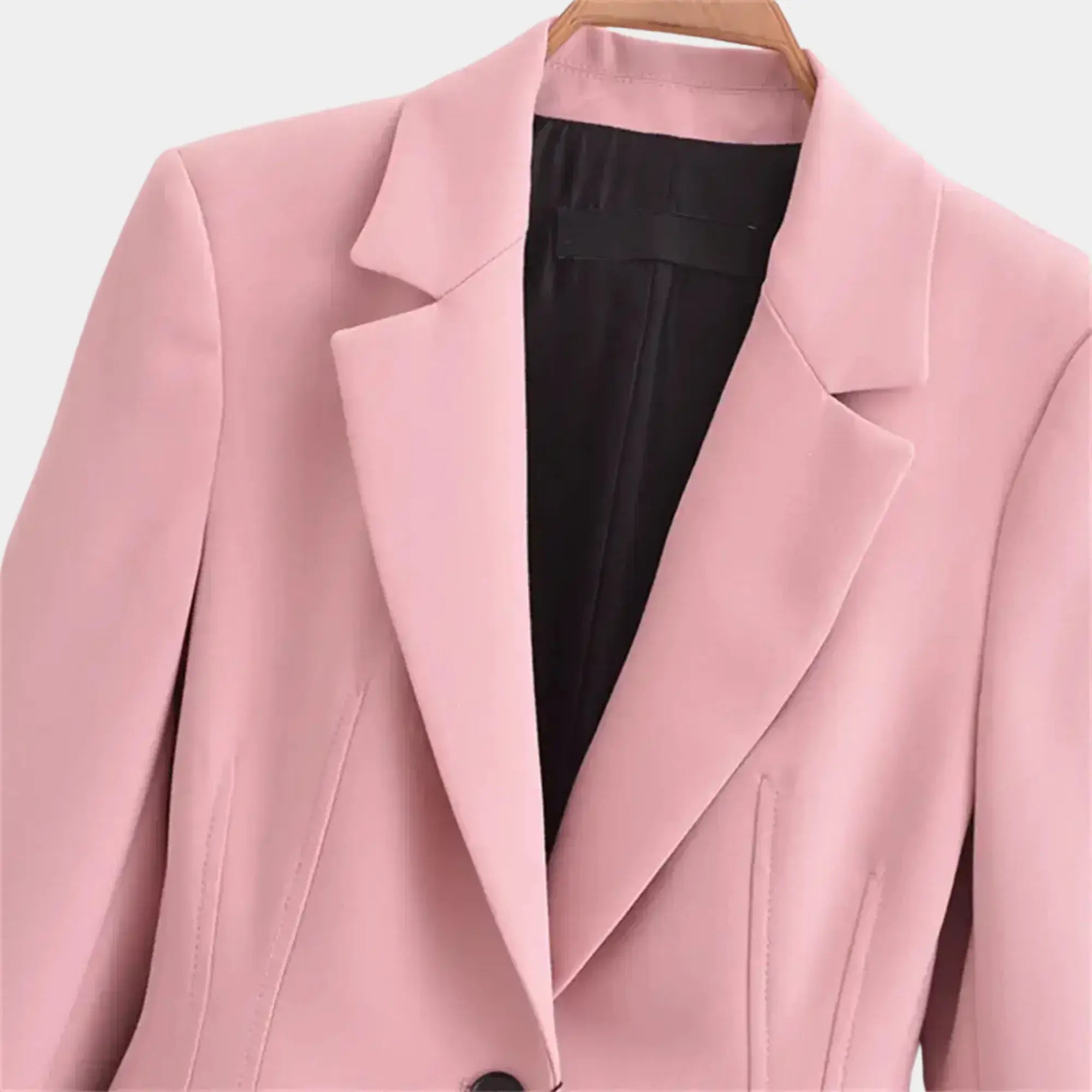 Detalhe da lapela clássica e do forro interno em blazer feminino rosa de alfaiataria premium