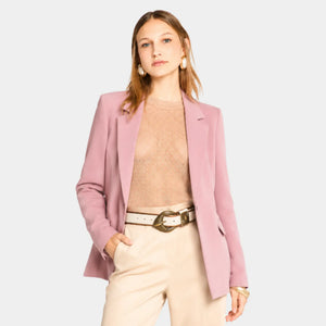 Mulher usando blazer feminino rosa de alfaiataria aberto com calça de cintura alta e visual elegante