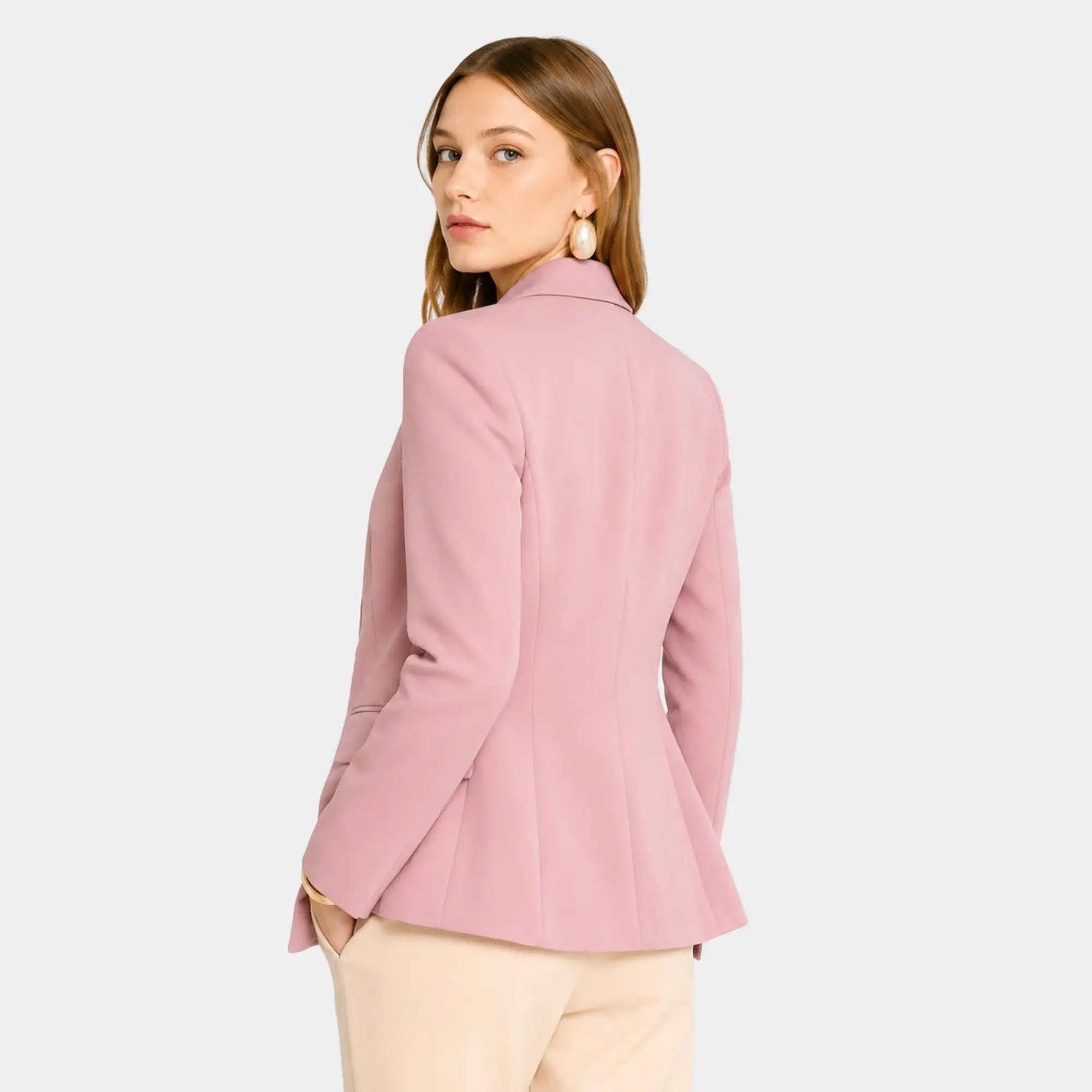 Mulher usando blazer feminino rosa de alfaiataria visto nas costas com modelagem acinturada e caimento elegante