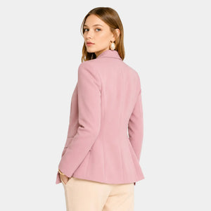 Mulher usando blazer feminino rosa de alfaiataria visto nas costas com modelagem acinturada e caimento elegante