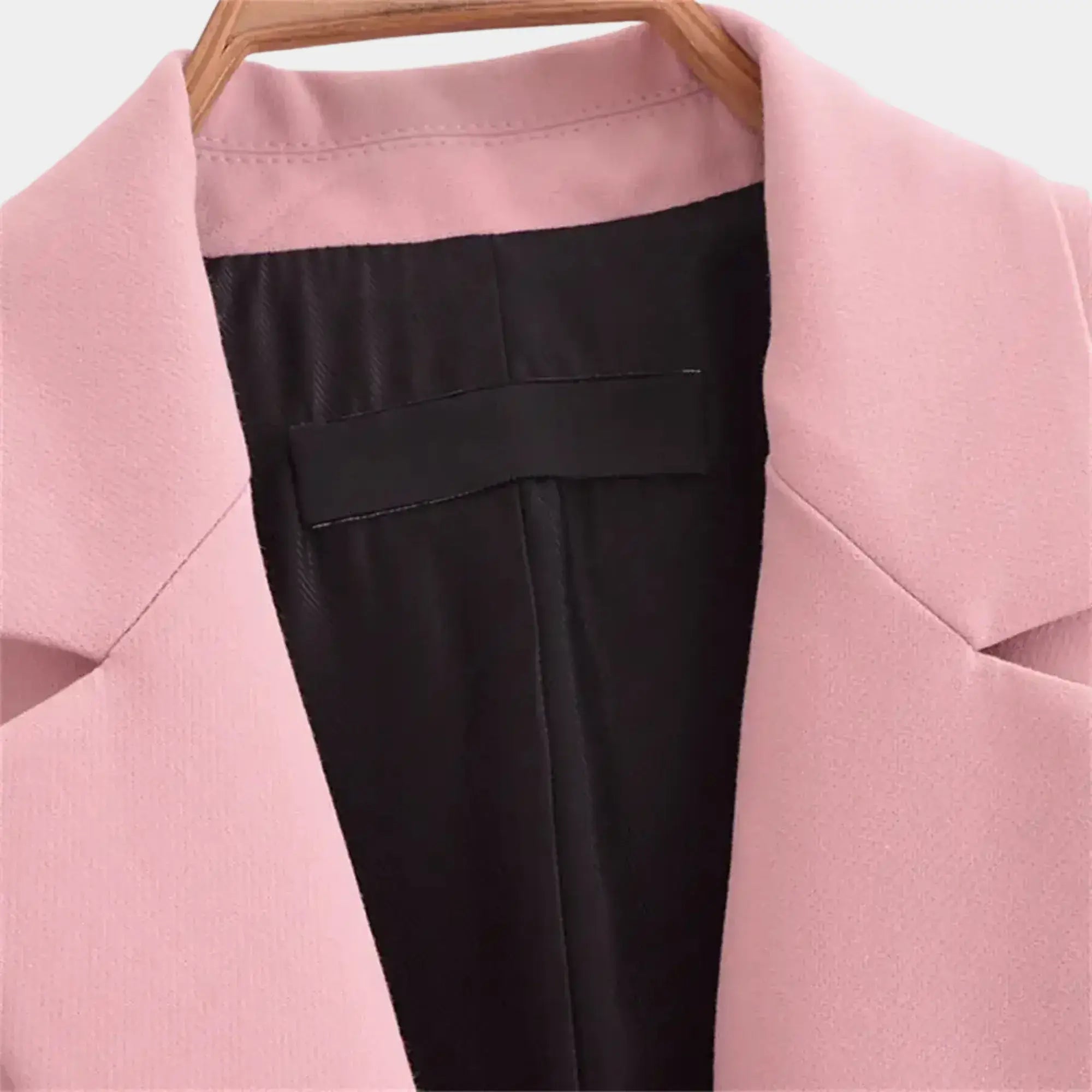 Detalhe interno do blazer feminino rosa de alfaiataria com lapela clássica, forro acetinado e acabamento premium