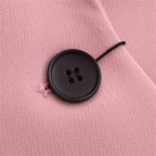 Detalhe do botão frontal em blazer feminino rosa de alfaiataria com acabamento elegante