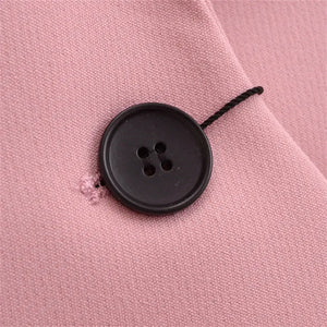 Detalhe do botão frontal em blazer feminino rosa de alfaiataria com acabamento elegante