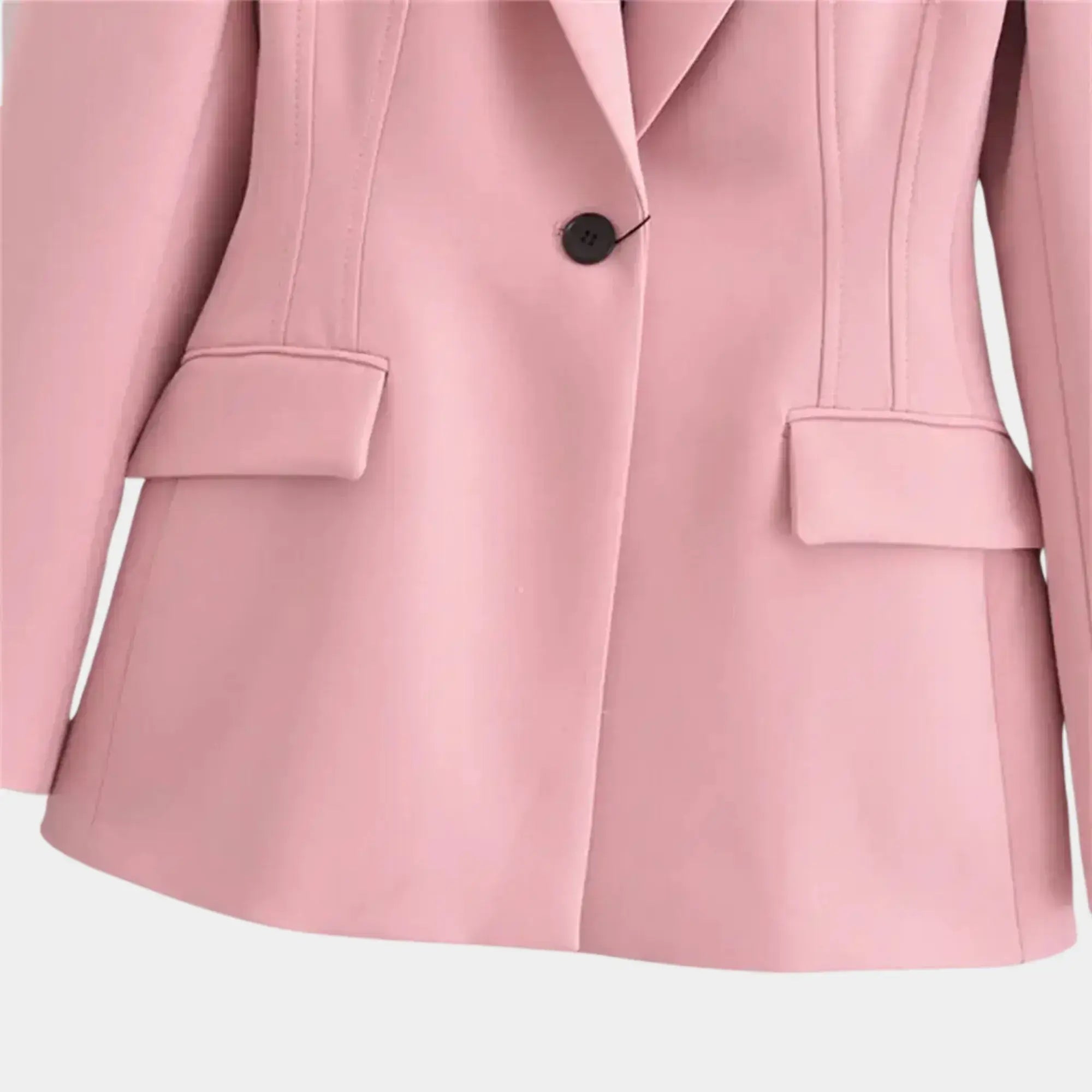 Detalhe dos bolsos com lapela e fechamento por botão único em blazer feminino rosa de alfaiataria