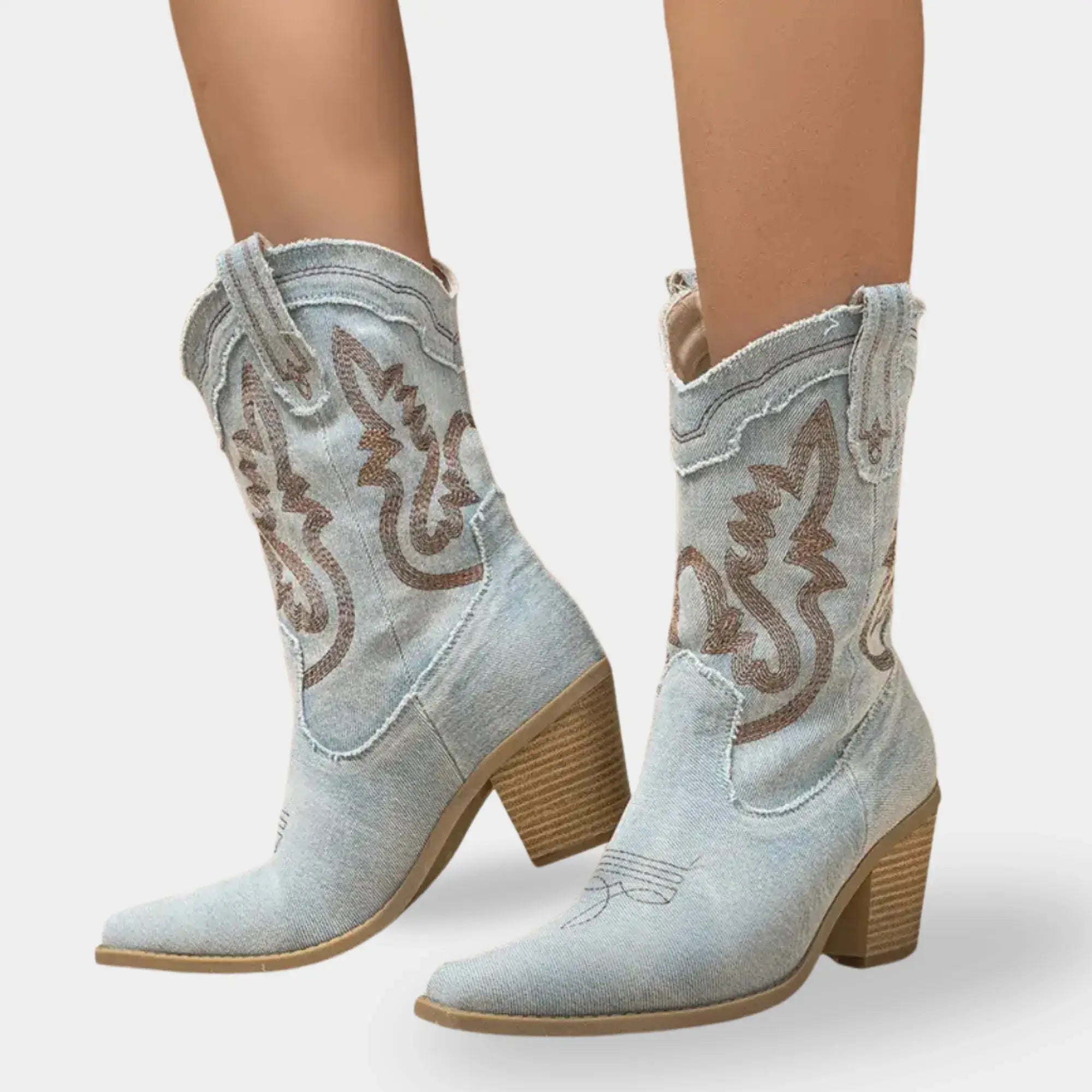 Bota country feminina jeans claro com bico fino, bordados decorativos e design western elegante.