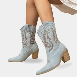 Bota feminina estilo texano em tecido denim claro com bordados contrastantes e solado resistente.