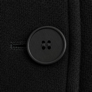 Detalhe do cinto ajustável em casaco feminino preto sofisticado com modelagem longa e acabamento clean luxury