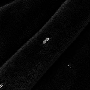 Detalhe do tecido teddy premium preto com acabamento peluciado sofisticado e toque ultra macio em casaco longo feminino elegante clean luxury