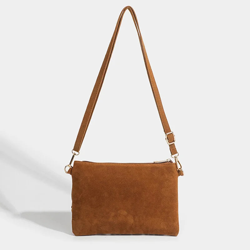 Bolsa crossbody de camurça caramelo vista de frente com a alça estendida