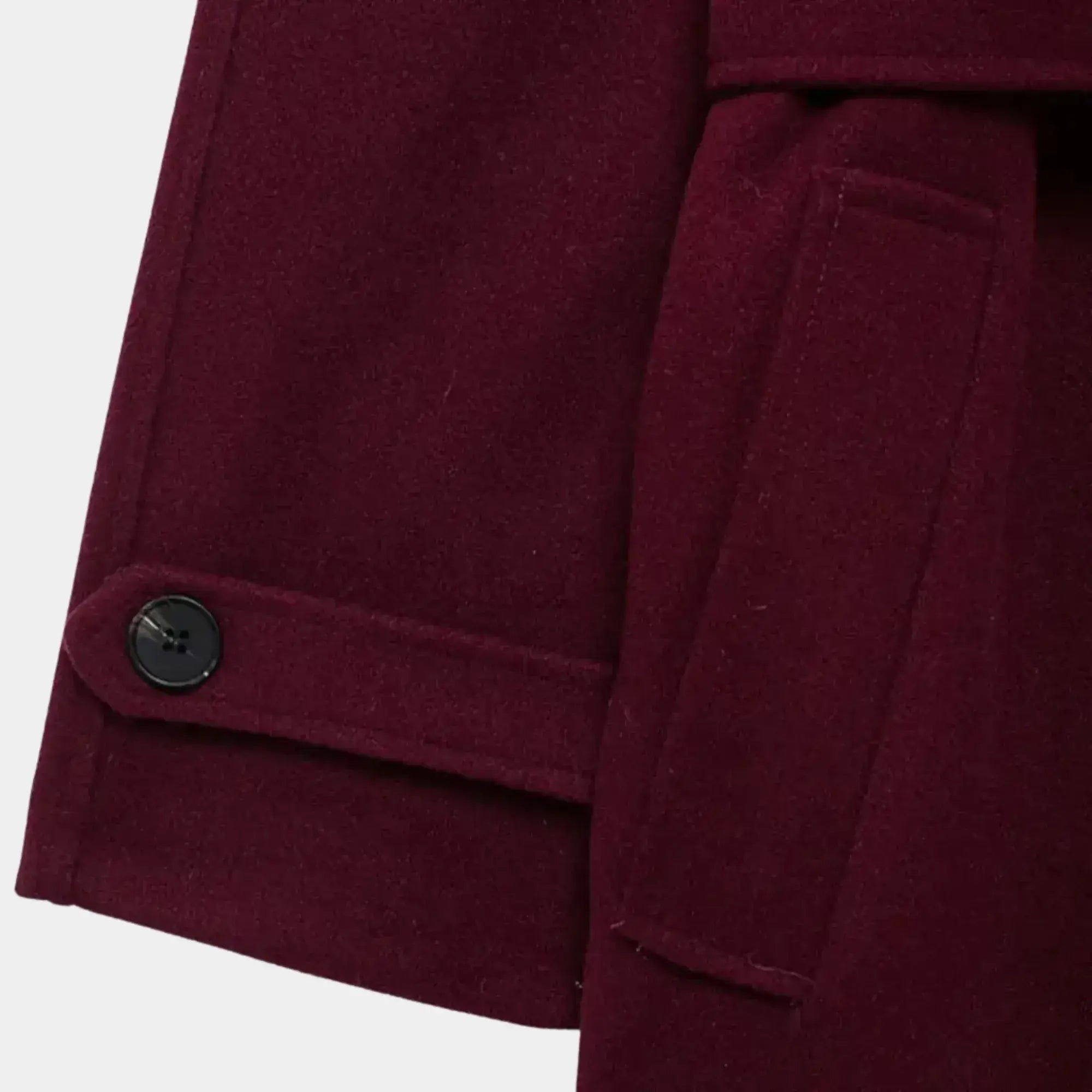 Detalhe do punho com botão, bolso lateral e acabamento premium do trench coat feminino longo vinho