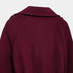 Detalhe traseiro do trench coat feminino longo vinho com acabamento sofisticado, costura estruturada e tecido encorpado