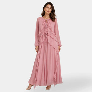 Mulher usando vestido longo boho chic rosa com decote V e mangas longas em ambiente de estúdio