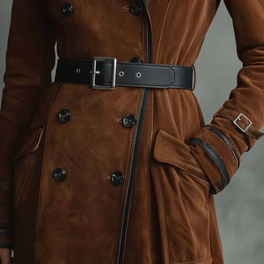 Detalhe do cinto preto de fivela e da botonadura dupla na frente do trench coat de camurça marrom
